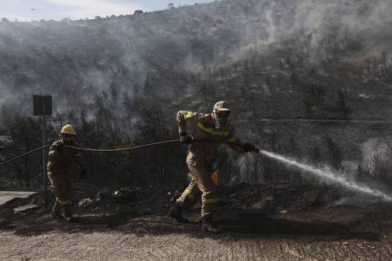 Grécki hasiči bojujú naďalej s lesným požiarom, poškodené sú domy aj autá